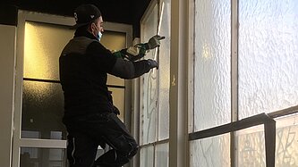 Zwei Handwerker bauen Fenster aus am Euskirchener Bahnhof. 