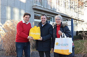 Carsten und Helga Lübke mit Euskirchens Bürgermeister Sacha Reichelt vor dem Rathaus.