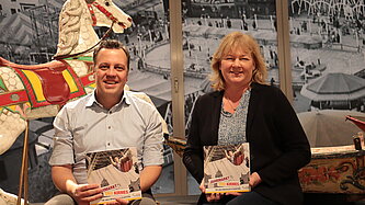 Bürgermeister Sacha Reichelt und die Museumsleiterin mit dem Ausstellungskatalog in der Ausstellung zur Geschichte der Kirmes. 