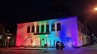 Das Alte Rathaus angeleuchtet in Regenbogenfarben.