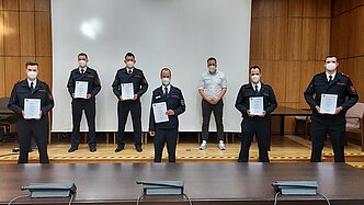 Bürgermeister Sacha Reichelt mit sechs Feuerwehrmännern bei der Urkundenübergabe