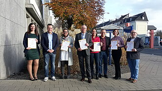 Euskirchens Bürgermeister mit den Heiratsstandesbeamten, die ihre Urkunden zeigen.